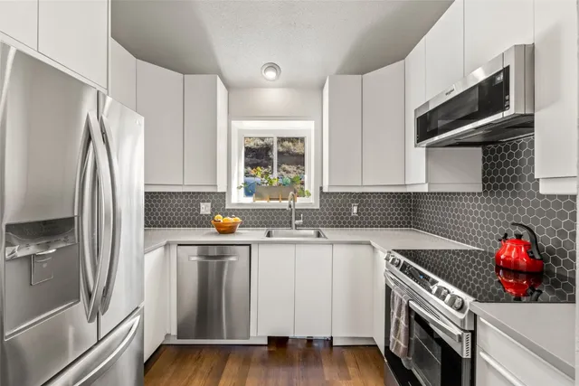 a kitchen with stainless steel appliances a sink stove and refrigerator