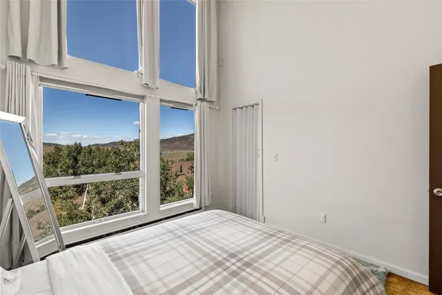 a view of a bedroom with wooden floor and a window