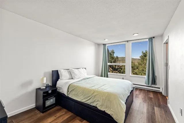 a large bed sitting in a bedroom next to a window