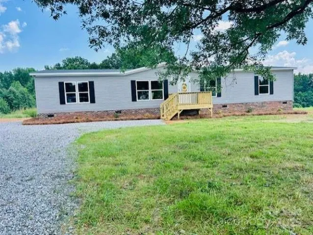 a view of a house with a backyard and a tree