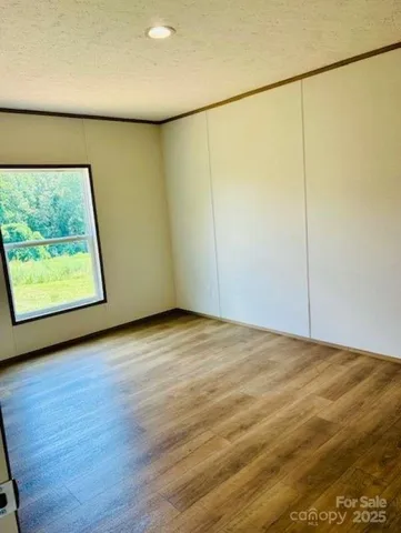 a view of a room with wooden floor and a window