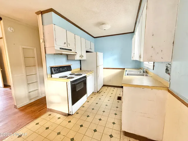 a kitchen with stainless steel appliances a stove a sink and a refrigerator