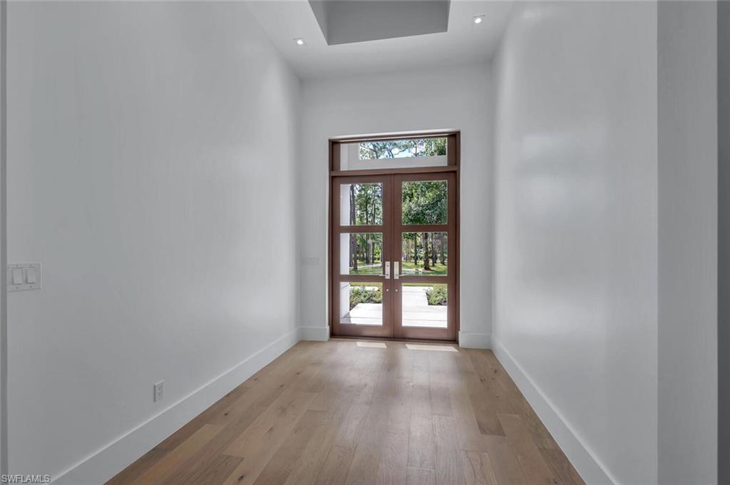 5253 Sycamore Drive Naples, FL 34119 - Photo 15 of 49 a view of an empty room with a window and wooden floor