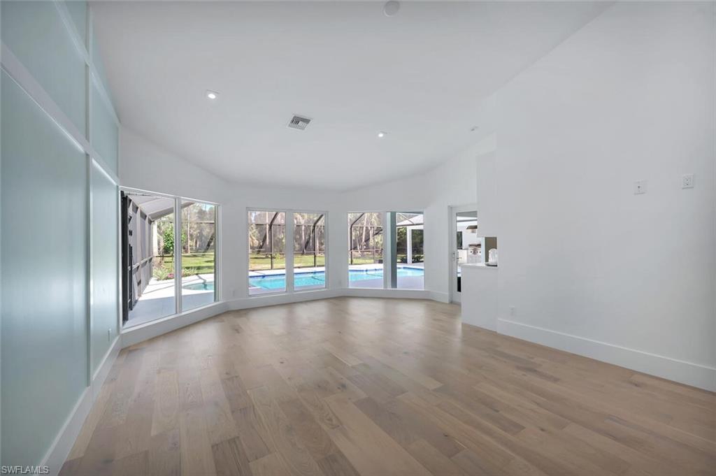 5253 Sycamore Drive Naples, FL 34119 - Photo 19 of 49 a view of an empty room with wooden floor and a window