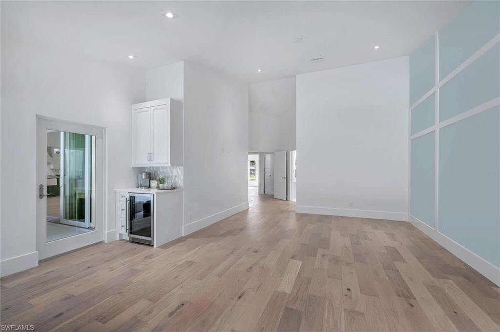 5253 Sycamore Drive Naples, FL 34119 - Photo 21 of 49 a view of empty room with wooden floor and kitchen