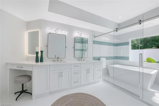 a spacious bathroom with a double vanity sink mirror and bathtub