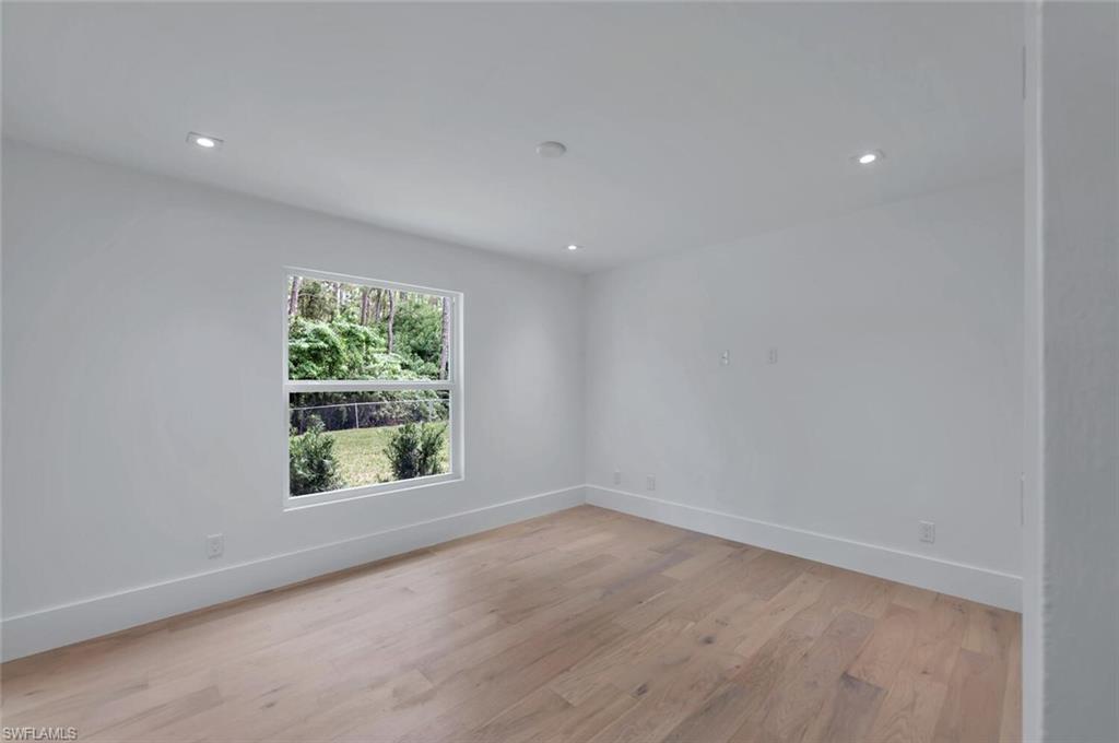 5253 Sycamore Drive Naples, FL 34119 - Photo 33 of 49 an empty room with wooden floor and windows