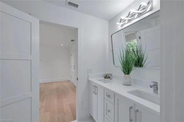 a kitchen with stainless steel appliances a white cabinets and a wooden floor