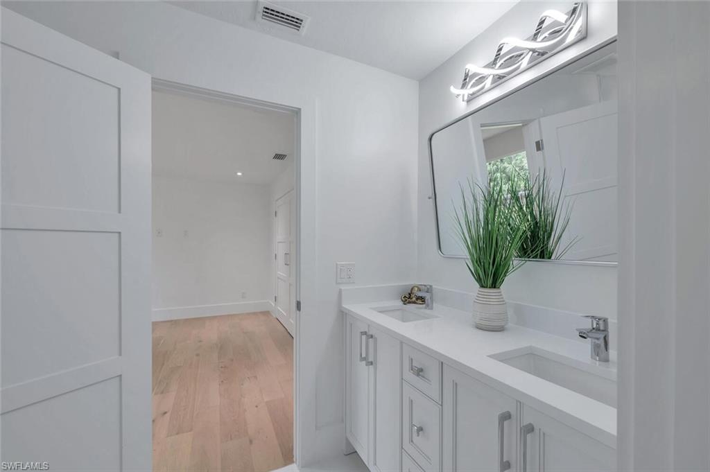 5253 Sycamore Drive Naples, FL 34119 - Photo 35 of 49 a bathroom with a sink a potted plant and a mirror