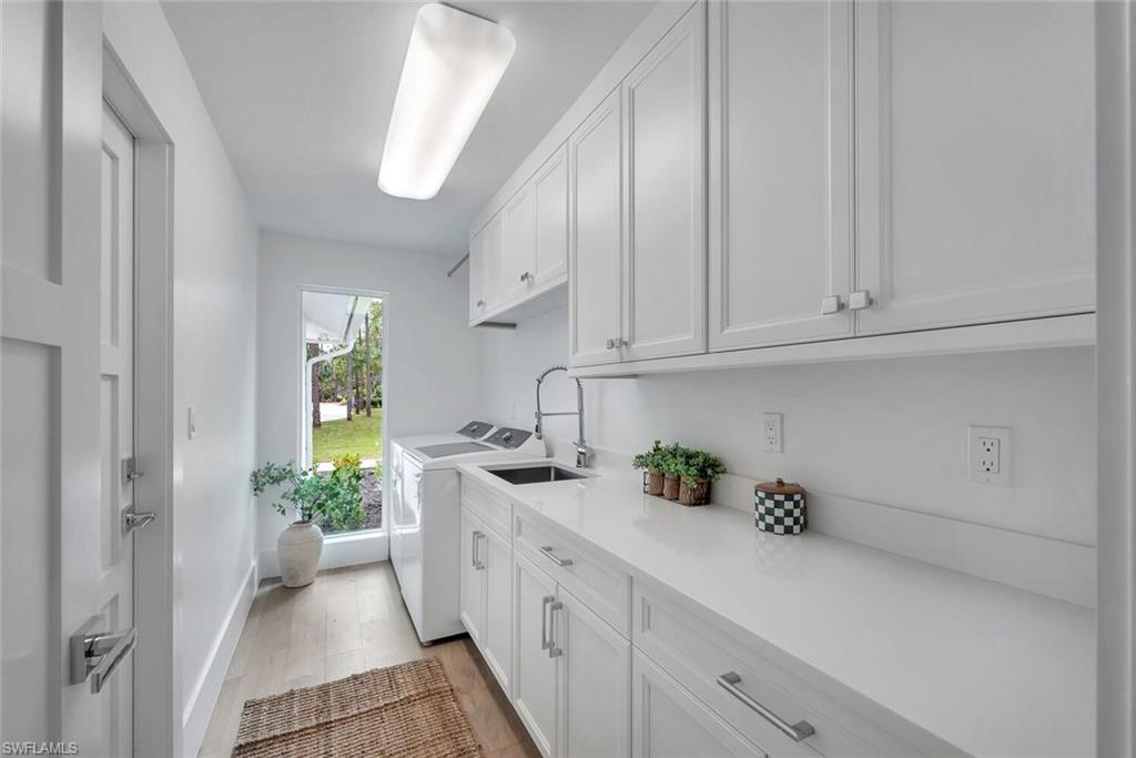 5253 Sycamore Drive Naples, FL 34119 - Photo 36 of 49 a kitchen with stainless steel appliances a white cabinets and a wooden floor