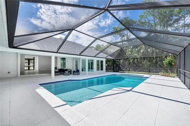 a view of a house with pool and chairs