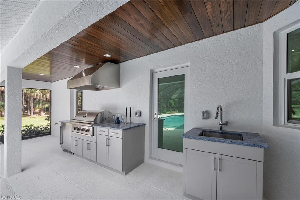 5253 Sycamore Drive Naples, FL 34119 - Photo 42 of 49 a kitchen with stainless steel appliances granite countertop a sink stove and cabinets