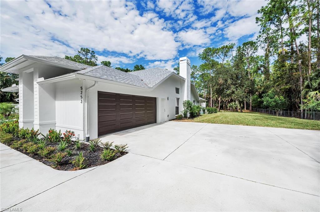 5253 Sycamore Drive Naples, FL 34119 - Photo 43 of 49 a front view of a house with a yard and garage