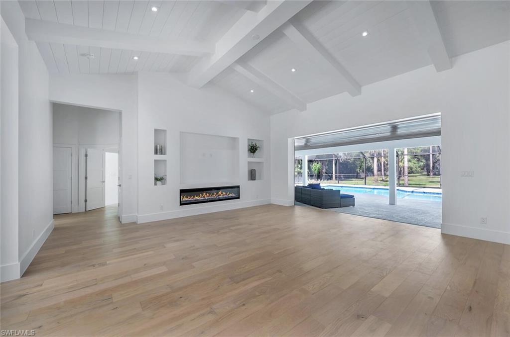 5253 Sycamore Drive Naples, FL 34119 - Photo 8 of 49 an empty room with wooden floor and windows