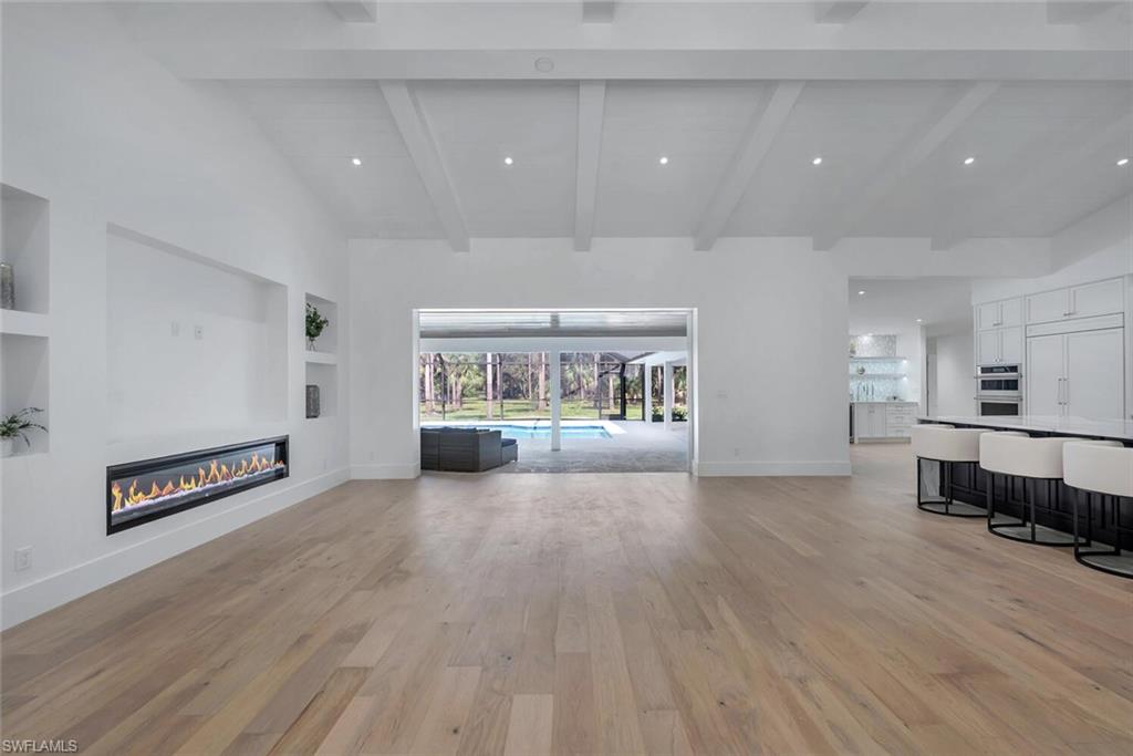 5253 Sycamore Drive Naples, FL 34119 - Photo 10 of 49 an empty room with wooden floor and furniture