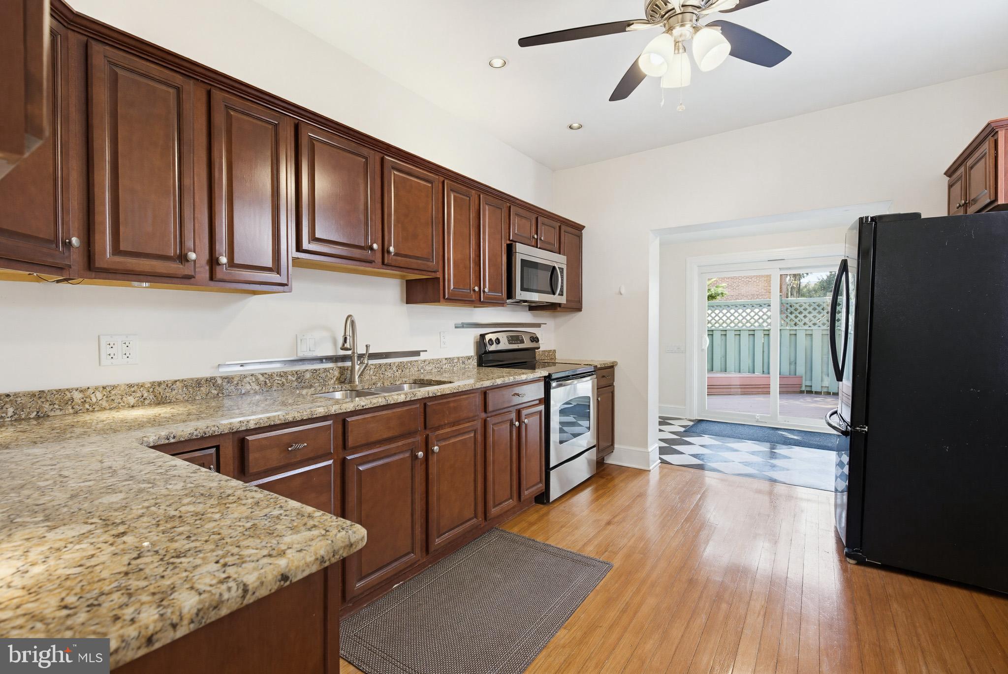 114 North Charlotte Street Lancaster, PA 17603 - Photo 10 of 40 a kitchen with stainless steel appliances granite countertop a refrigerator a sink dishwasher a stove and white countertops with wooden floor