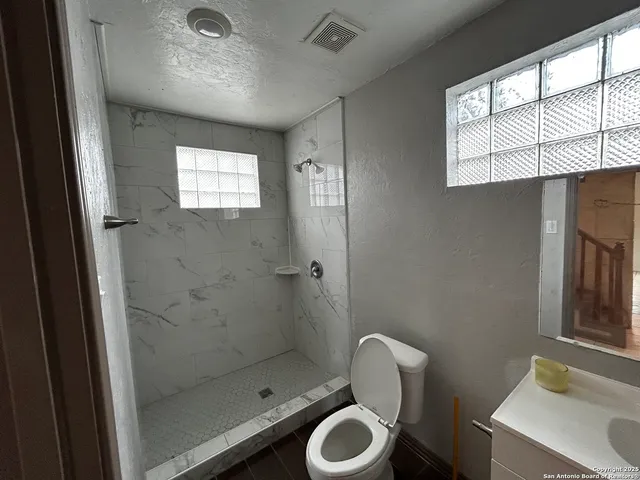a bathroom with a toilet a sink and window