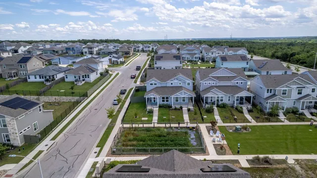 an aerial view of a residential houses with yard