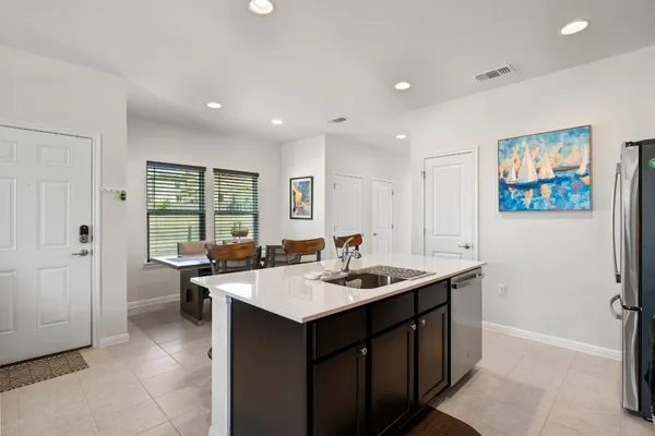 a living room with furniture kitchen view and a chandelier