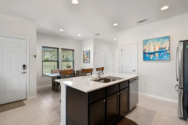 a living room with furniture kitchen view and a chandelier