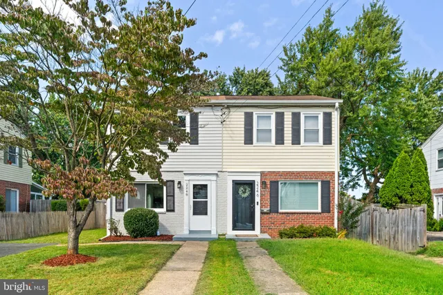 a front view of a house with a yard and potted plants