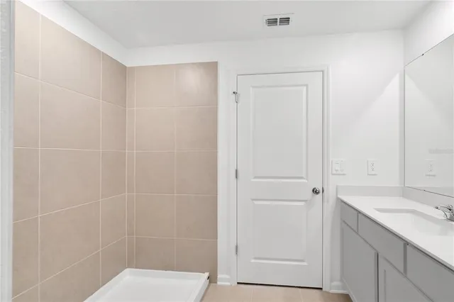 a bathroom with a granite countertop sink a shower and a mirror