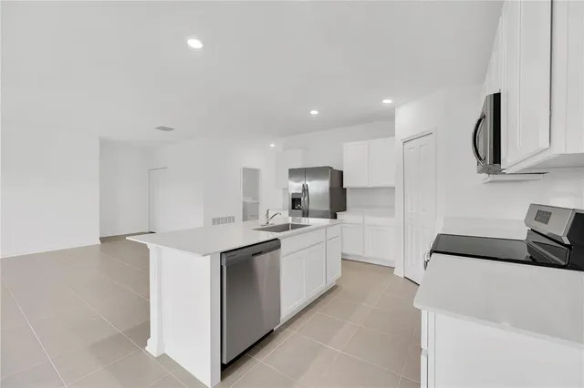 a kitchen with stainless steel appliances a sink stove and refrigerator