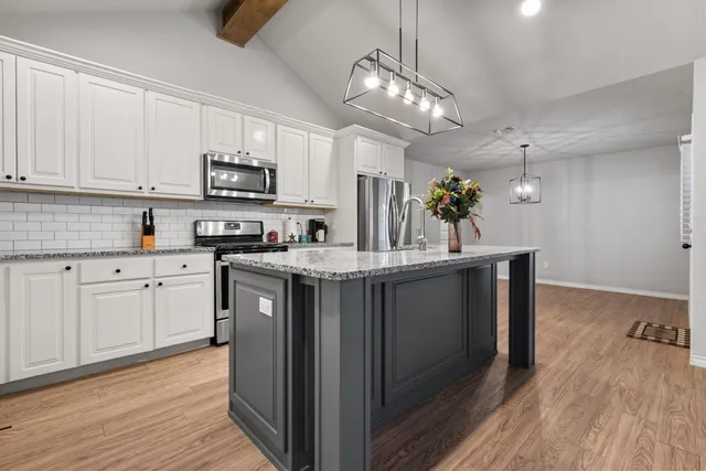 a view of empty room with wooden floor and window