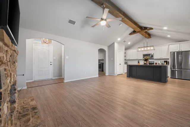 an empty room with windows and fan
