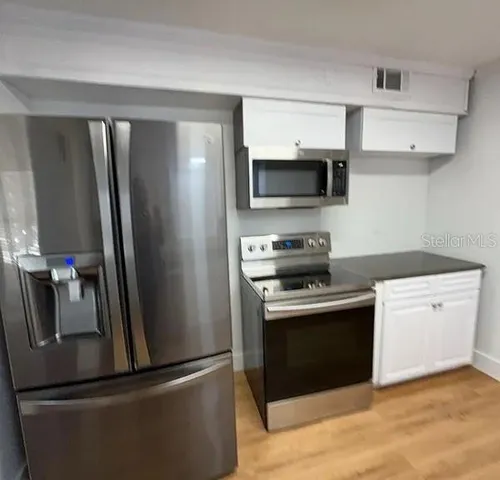 a kitchen with stainless steel appliances granite countertop a refrigerator stove and microwave