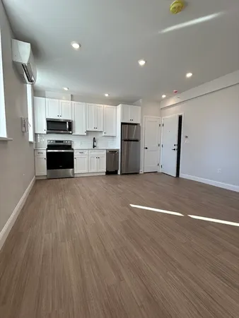 a view of kitchen with wooden floor and electronic appliances