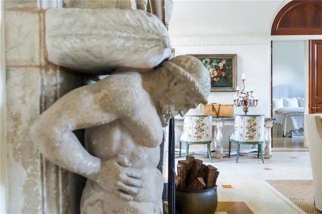 a living room with couches a chandelier and a large mirror with wooden floor