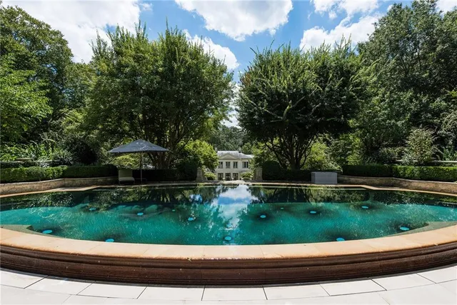a front view of a house with garden and sitting area