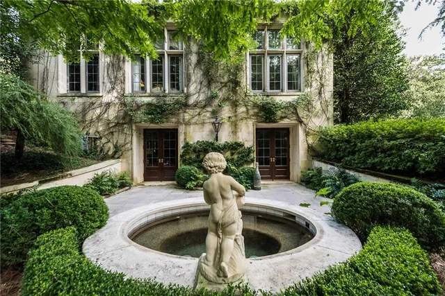 a front view of a house with a yard and potted plants