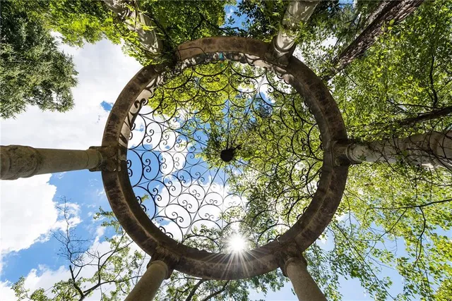 an aerial view of a house with outdoor space and trees all around