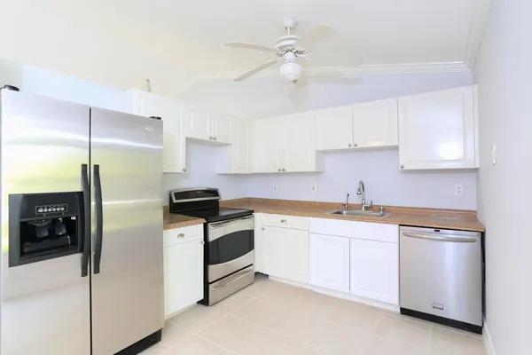 a kitchen with stainless steel appliances white cabinets and a refrigerator