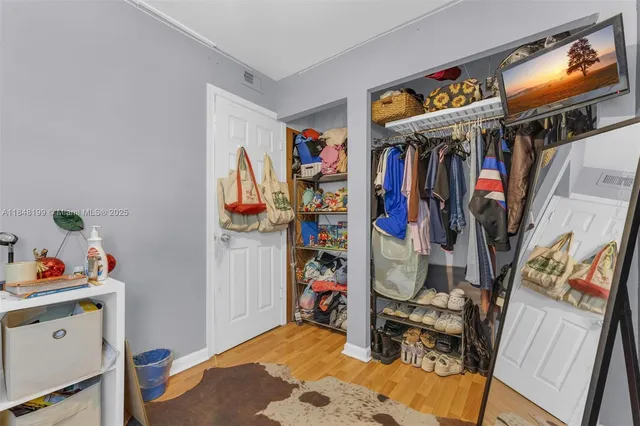 a view of walk in closet with clothes and shoes