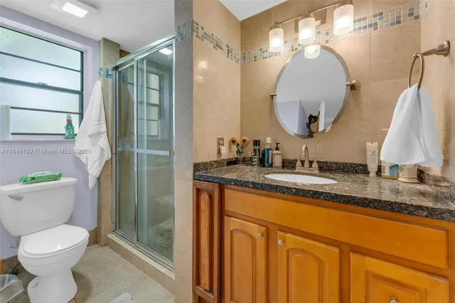 a bathroom with a granite countertop sink toilet and a mirror