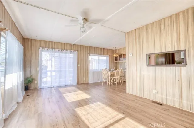a view of a livingroom with wooden floor and a kitchen space