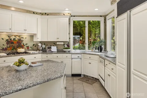 a kitchen with granite countertop a sink stove and cabinets