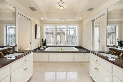 a large white bathroom with a sink a mirror and a shower
