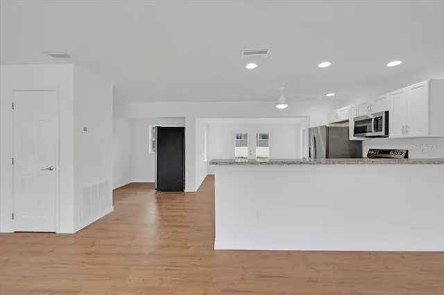 a view of kitchen with kitchen island microwave and refrigerator