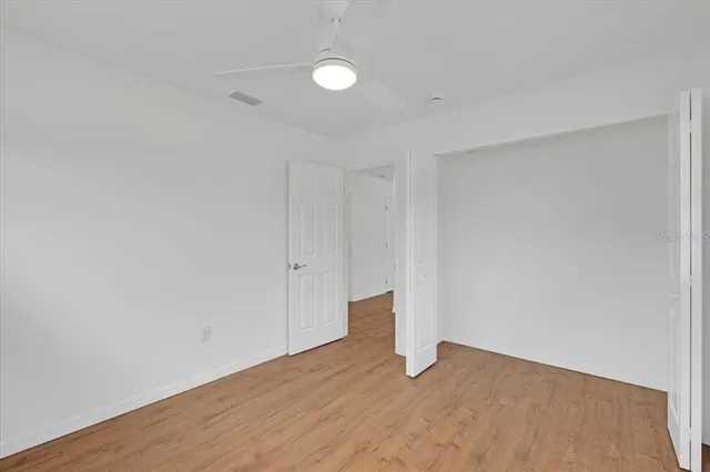 a view of an empty room with wooden floor
