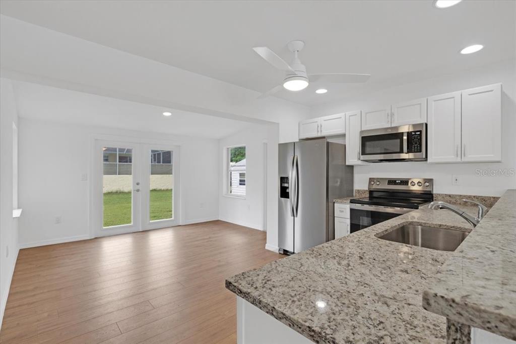 2206 Mark Avenue Punta Gorda, FL 33950 - Photo 7 of 22 a kitchen with stainless steel appliances granite countertop a sink refrigerator and microwave