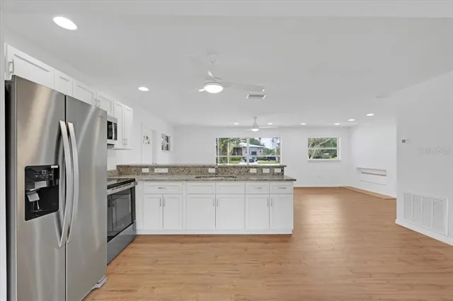 a kitchen with stainless steel appliances granite countertop a refrigerator and a sink
