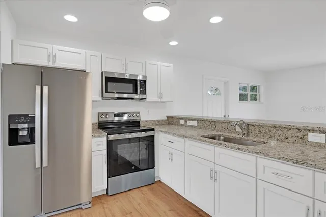 a kitchen with stainless steel appliances granite countertop a stove a sink and a refrigerator