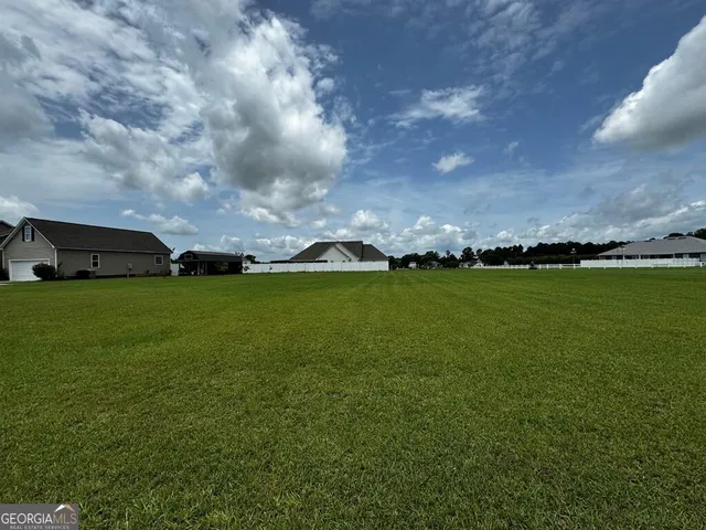 a view of yard with swimming pool and green space