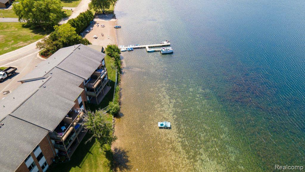 1974 Klingensmith Road, Unit 4 Bloomfield Hills, MI 48302 - Photo 32 of 35 Waterfront condominium complex featuring multiple private balconies, a private beach, and a dock with boat slips