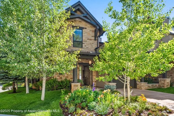 a front view of a house with a tree