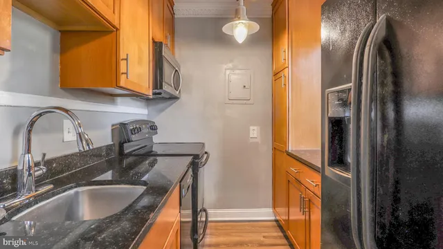 a kitchen with stainless steel appliances granite countertop a sink a refrigerator and a granite counter tops